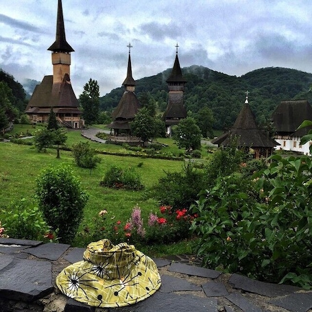 A church with multiple spires, surrounded by lush greenery and a stone pathway.