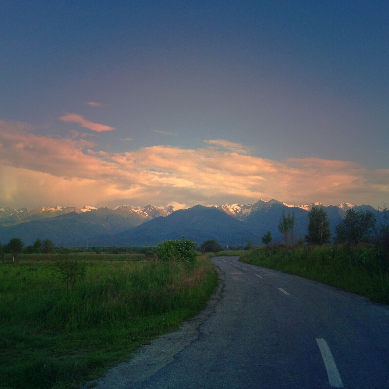 A winding road with a mountainous landscape in the background.