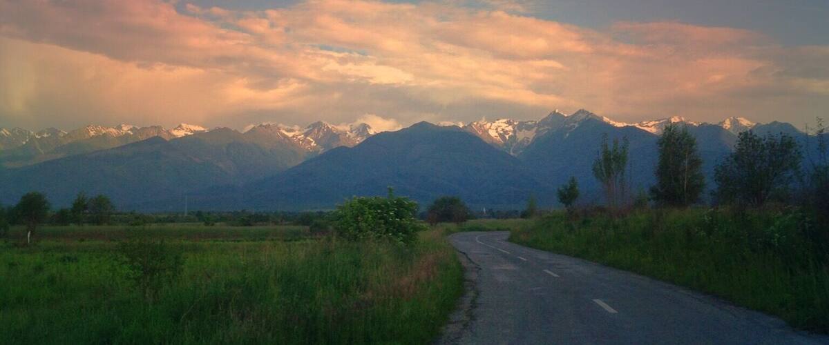 A winding road with a mountainous landscape in the background.
