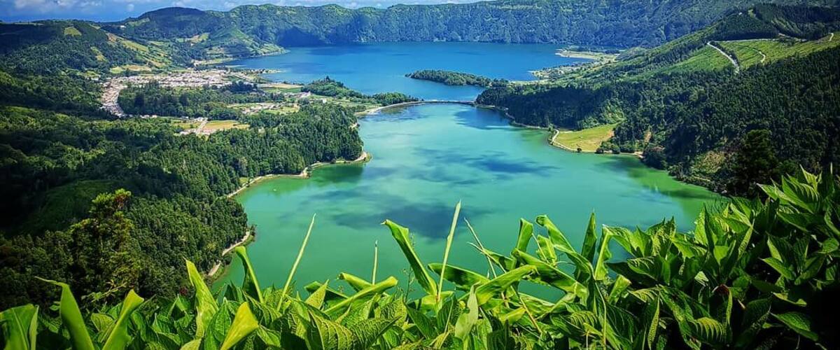 Lagoa das Sete Cidades is a twin lake situated in the crater of a dormant volcano on the Portuguese archipelago of the Azores. It consists of two small, ecologically different lakes connected by a narrow strait, which is crossed by a bridge. The volcano is located on the western third of the island of São Miguel.