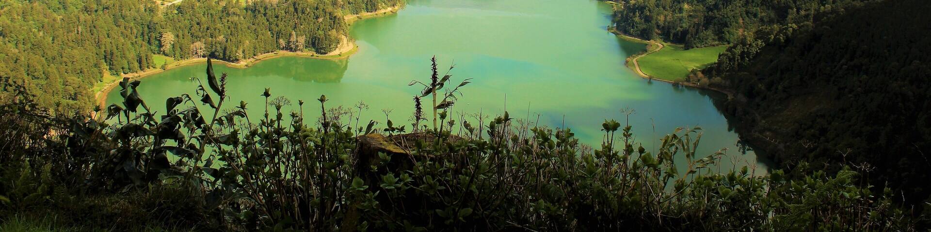 I took this on March 22nd in the Azores Islands, Portugal! It features Lagoa das Sete Cidades (Lagoon of the Seven Cities). This is a twin lake situated in the crater of a dormant volcano. It's one of the Azores' most beautiful and iconic spots! Before the construction of the bridge it was originally one lake. Now it is the "Green Lake" and "Blue Lake". And in the distance you can see the Atlantic Ocean! I actually visited it twice :). On the 2nd day it was much more foggy and cloudy but still very nice!! On both days there was a real feeling of serenity :). I also saw a couple of other lakes similar to this, too. A truly magical green island!!