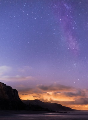 This is one of the beaches from this area with less light pollution, so during summer time it's one of the best places to shoot the milkyway (the orange light in the clouds is the light from the next city. 
Careful because the beach at night it's pitch black, so careful with the waves