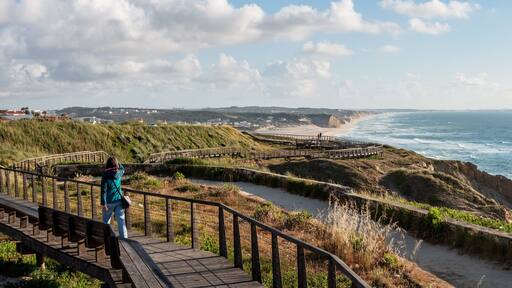 A young woman walking on a boardwalk at the Portuguese coast near Foz do Arelho