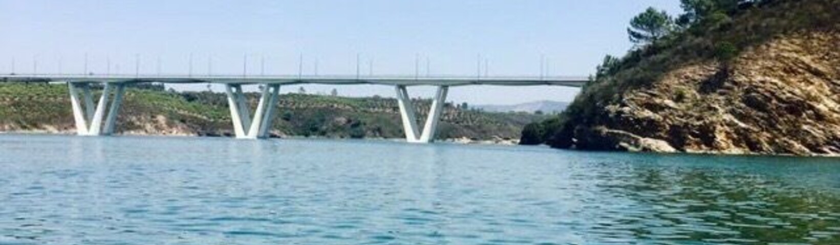 Un puente sobre una masa de agua con una costa rocosa.