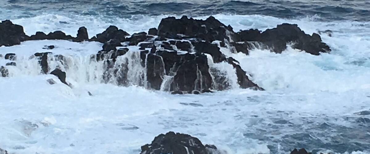 A rocky coastline with waves crashing against the rocks.