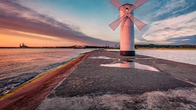 Astonishing summer view of Stawa windmill. Breathtaking sunrise on Szczecin Lagoon. Nice morning seascape of Baltic Sea, Swinoujscie, Western Pomerania, Poland, Europe. Traveling concept background..