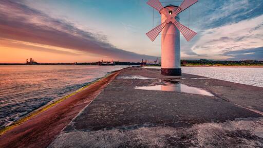 Astonishing summer view of Stawa windmill. Breathtaking sunrise on Szczecin Lagoon. Nice morning seascape of Baltic Sea, Swinoujscie, Western Pomerania, Poland, Europe. Traveling concept background..
