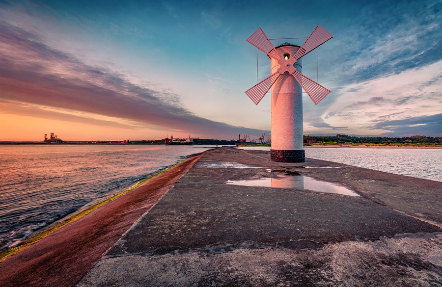 Astonishing summer view of Stawa windmill. Breathtaking sunrise on Szczecin Lagoon. Nice morning seascape of Baltic Sea, Swinoujscie, Western Pomerania, Poland, Europe. Traveling concept background..