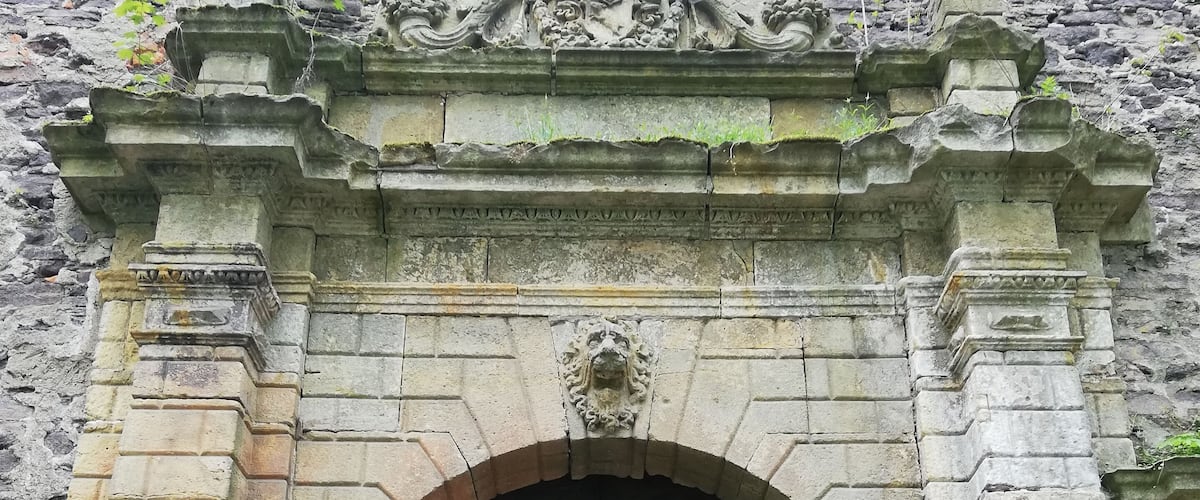 A large, ornate stone door with intricate carvings and a symmetrical design.