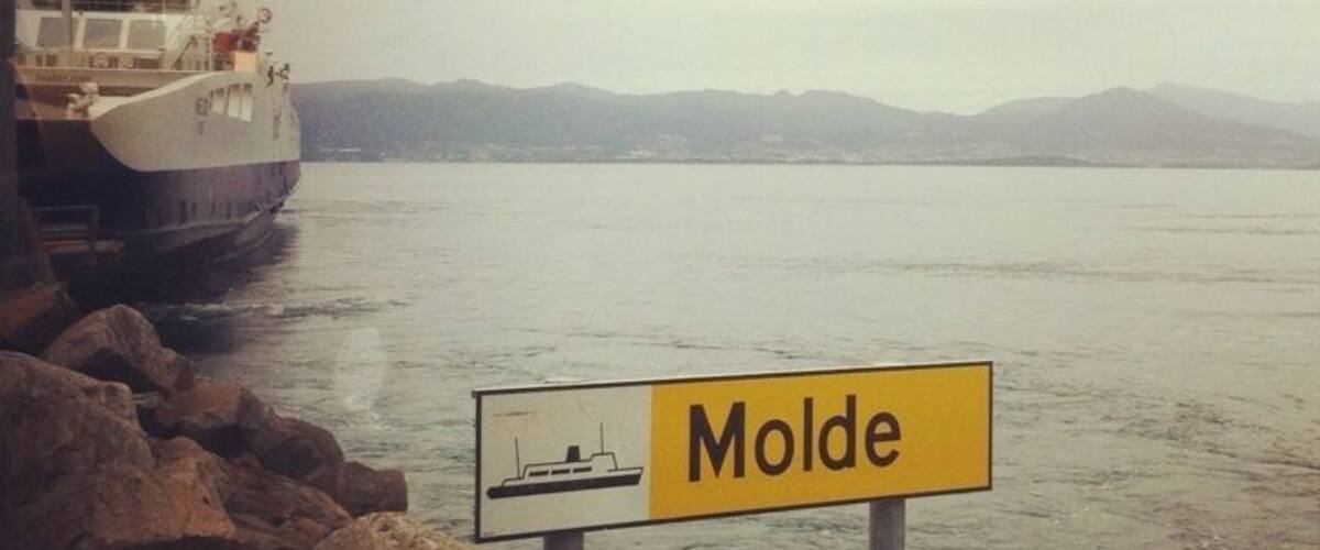 A ferry docked at a harbor with a sign reading "Molde".