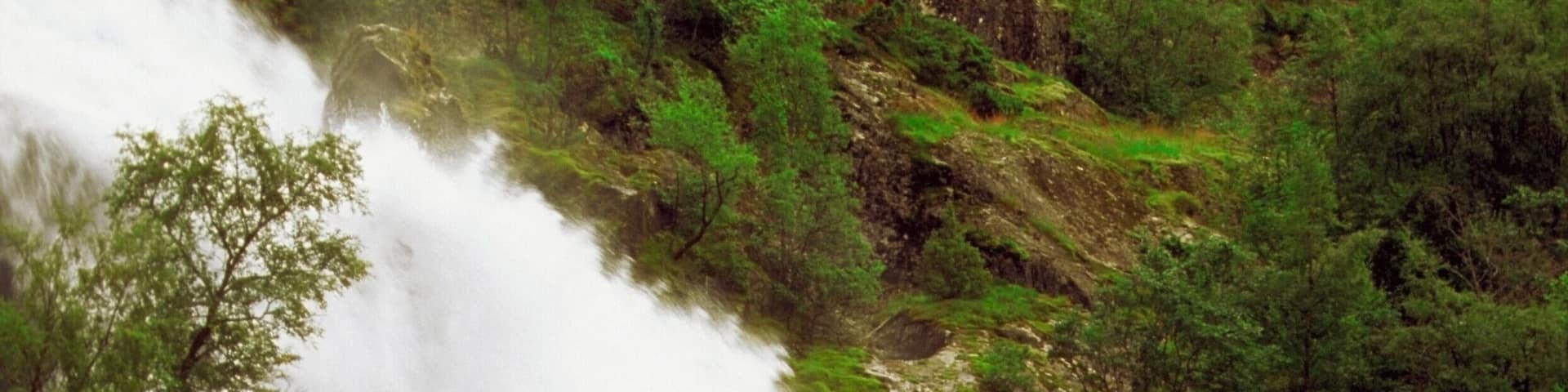 Tourist crossing a waterfall on a bridge with a horse cart, Olden, Norway