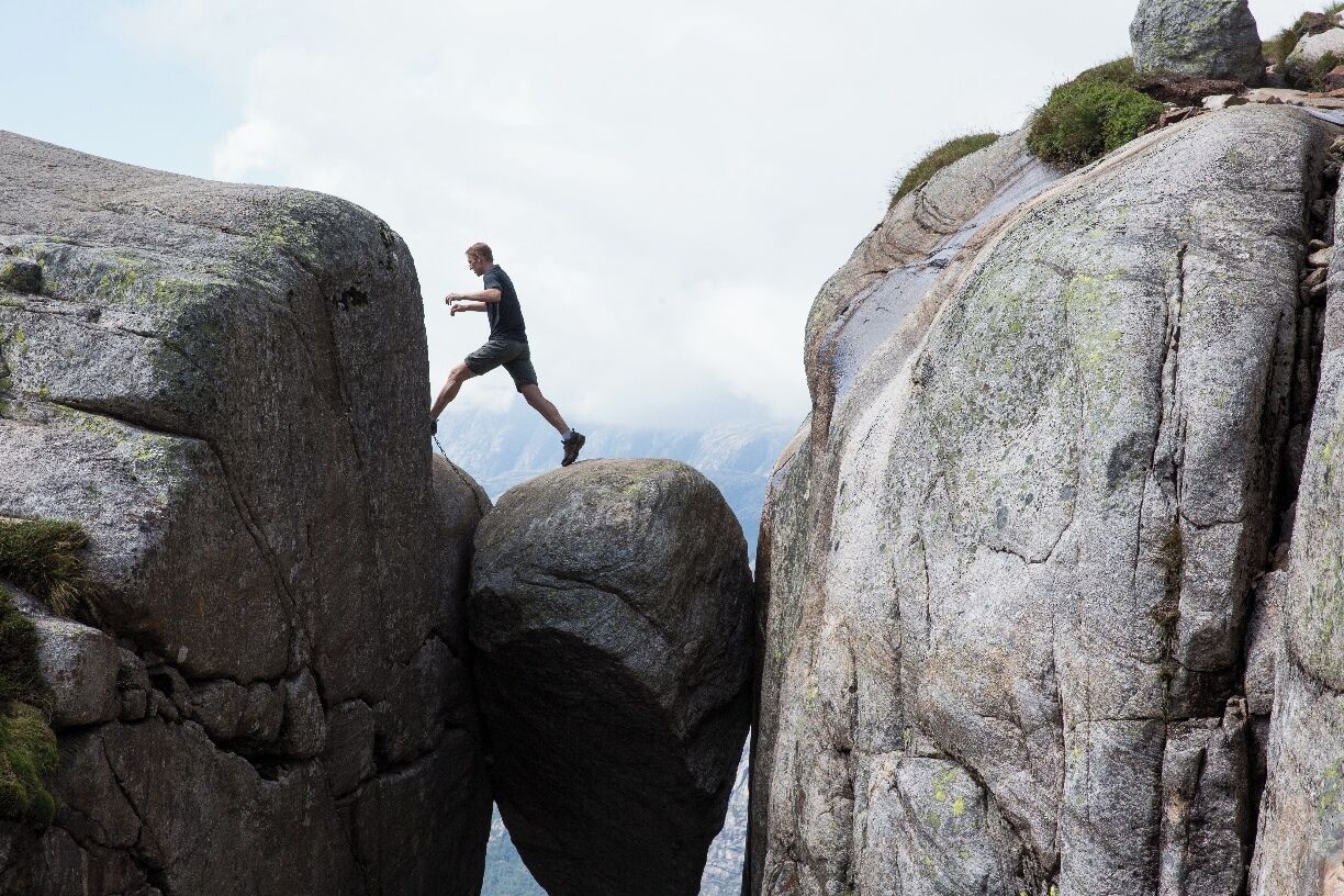 A person climbing between large rock formations.