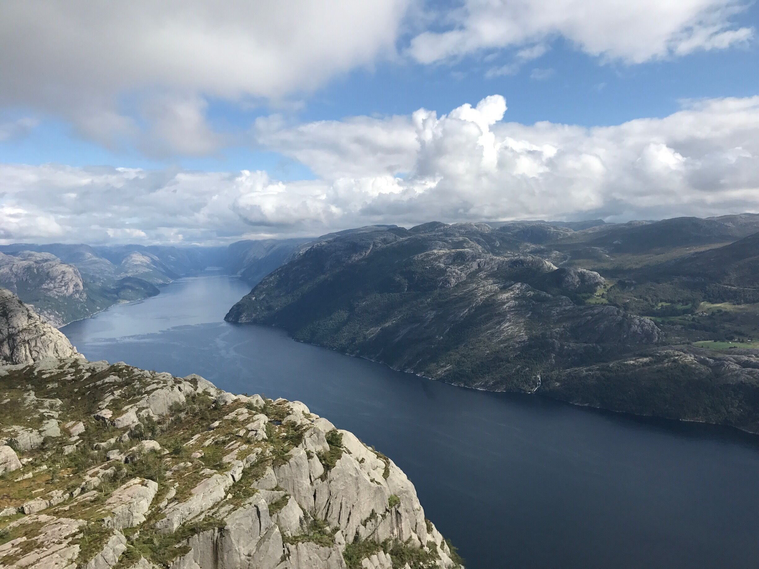 A mountainous landscape with a lake surrounded by rocky terrain and sparse vegetation.