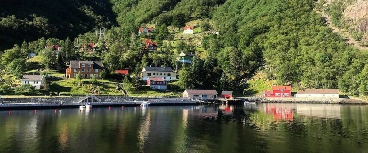 A lake with houses on the hillside and a bridge in the foreground.