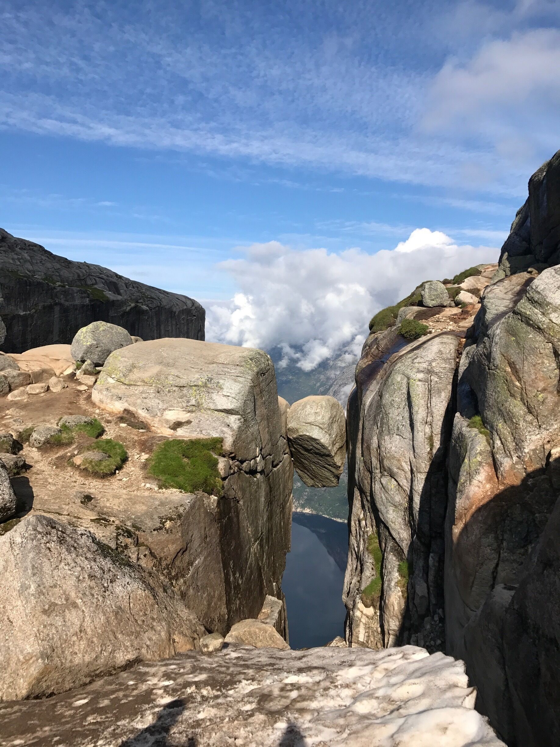 A rocky landscape with large boulders and a view of a lake below.