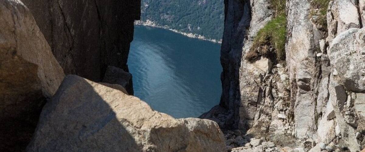 A rock formation with a natural arch over a body of water.
