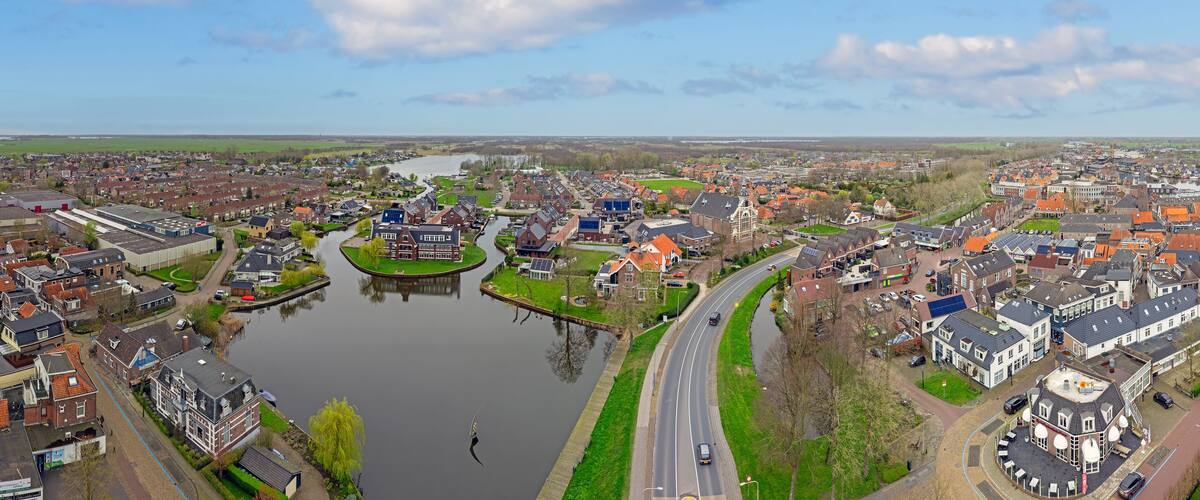 A river winding through a town with historic buildings and a modern bridge.