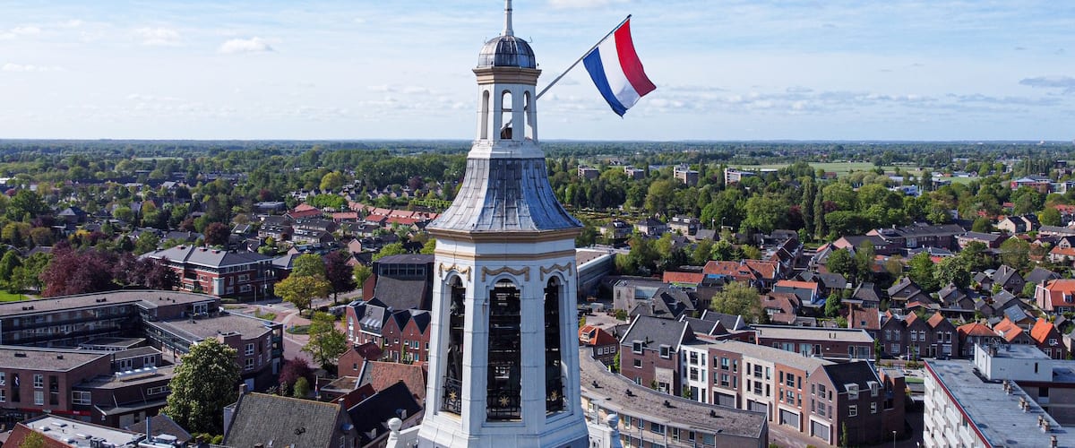 A town with a prominent tower and a flag.