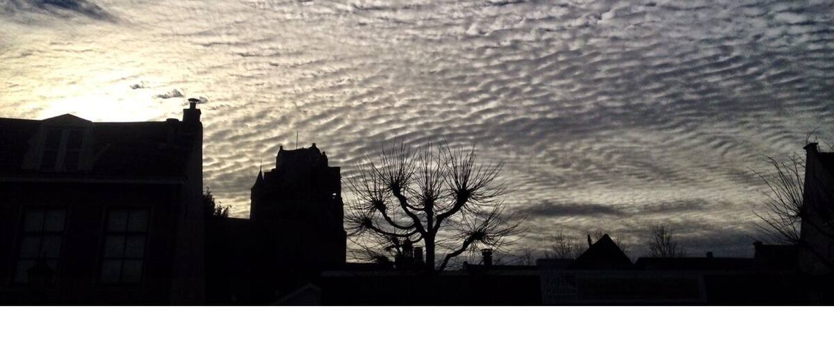 A sunset with a cloud pattern over a cityscape.
