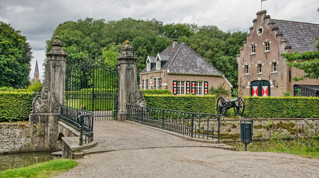 Wijhe,The Netherlands, August 7, 2021: bridge, gate and historic buildings of De Gelder estate with a vista towards the town's church tower in the distance