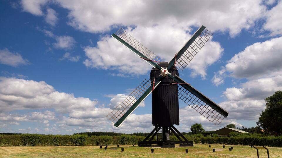 A large windmill in a field with a clear sky.