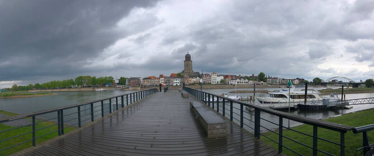 A wooden boardwalk leading to a tower, a river, and a bridge.