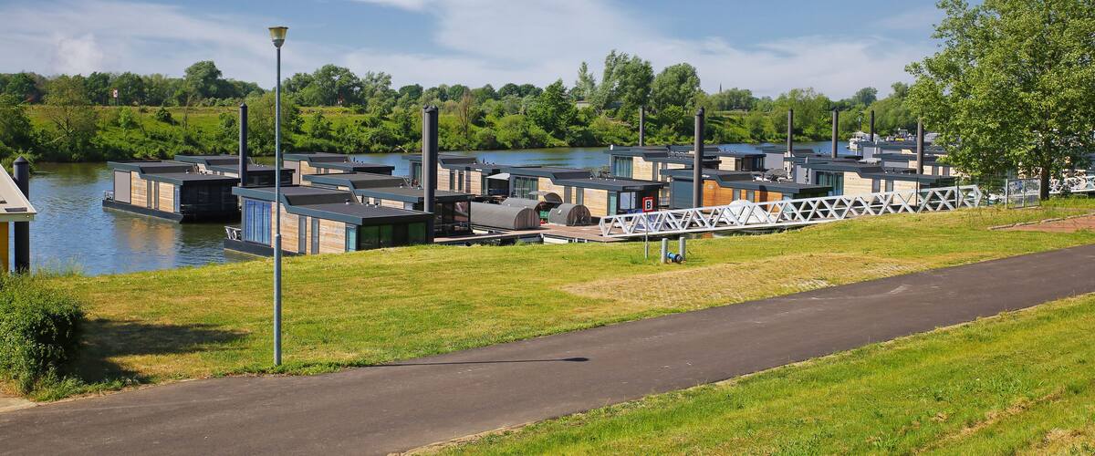 A riverside area with floating houses and a pedestrian path.