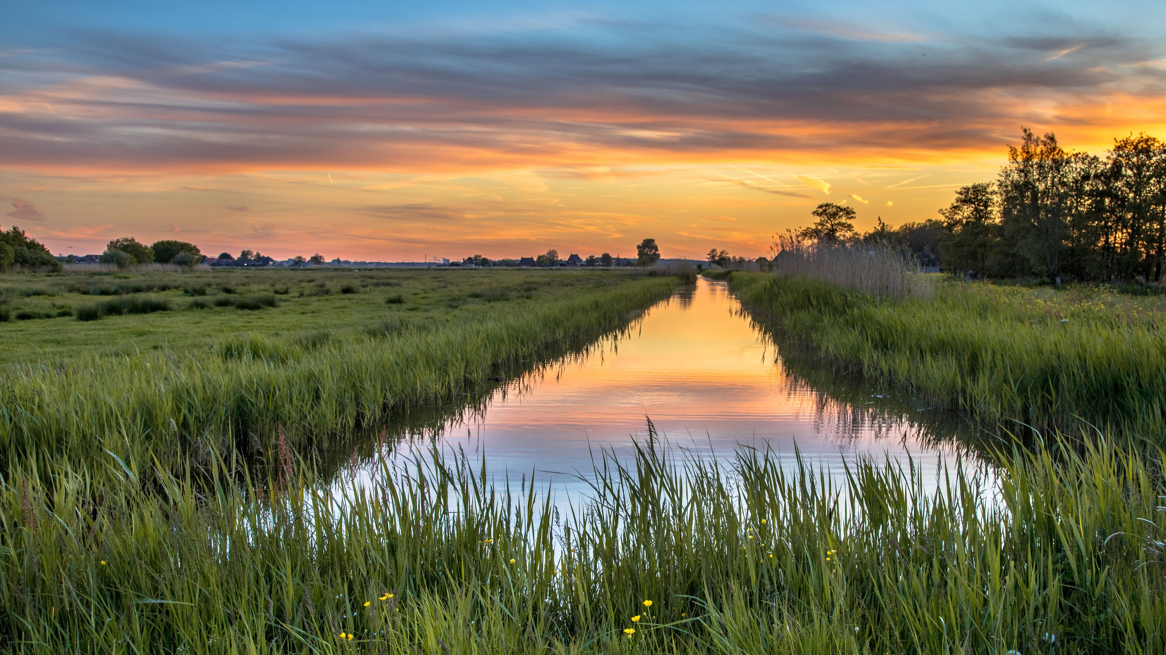 Sunset over canal in Historic dutch landscape