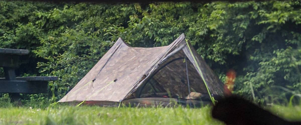 A campfire with a tent in the background.