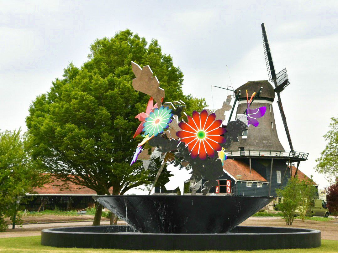 A windmill, a sculpture with colorful flowers, and a tree in a park.