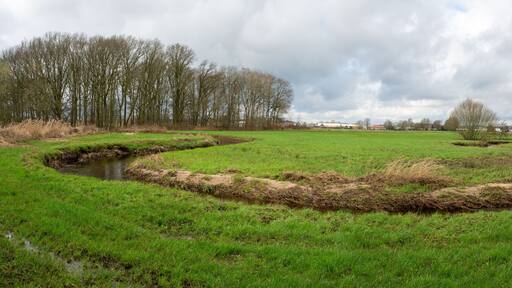 Rovertse Leij river winding through meadows outside of Goirle in The Netherlands