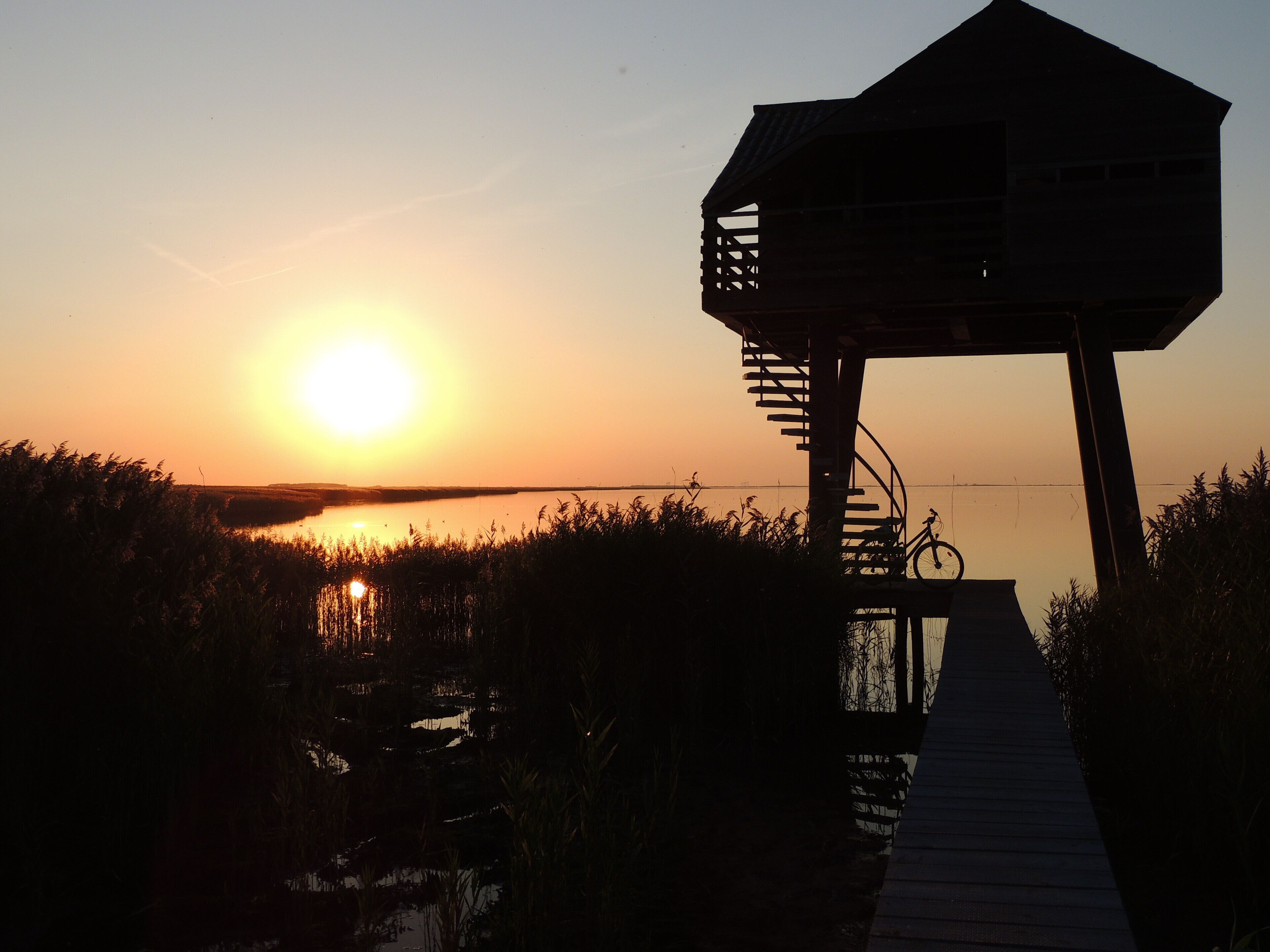 De Kiekkaaste(Vogelkijkhut) met de ondergaande zon. Nieuwe Statenzijl.