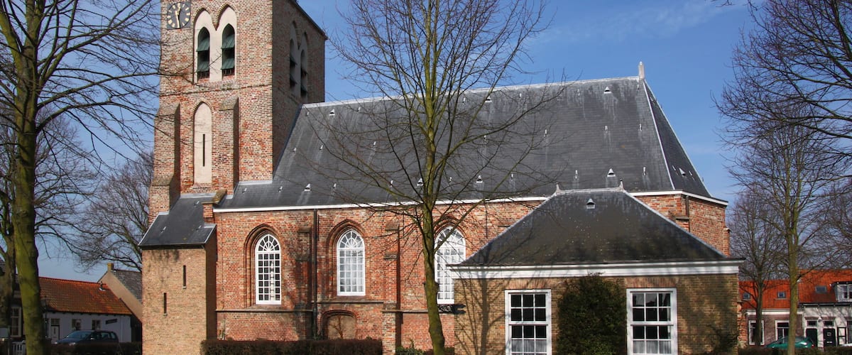 A historic brick church with a prominent tower and arched windows.