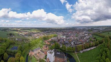 Wide aerial panorama of Huis Berg castle manor in Dutch province of Gelderland seen from above. Medieval brick defense building