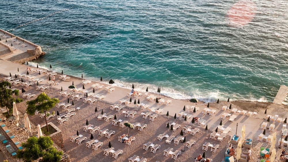 top view of the illuminated by the setting rays of the sun the beach on the Adriatic sea in the town of Dobra Voda, Montenegro