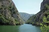 Ein Fluss schlängelt sich durch eine tiefe Schlucht mit steilen Klippen und üppiger Vegetation.