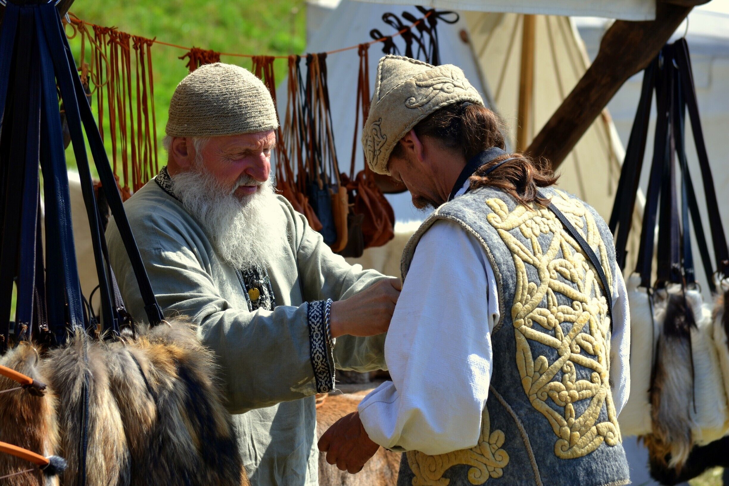 Two individuals in historical costumes exchanging a small object.
