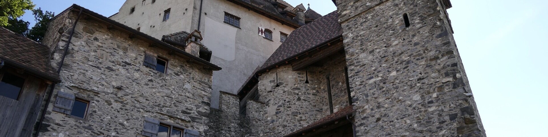 Un edificio histórico de piedra con un tejado empinado y una torre.