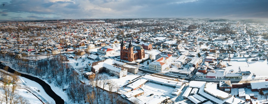 A snow-covered town with a prominent church and a train track.