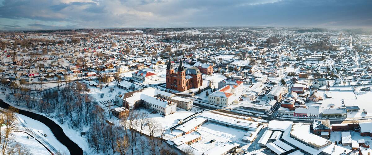 A snow-covered town with a prominent church and a train track.