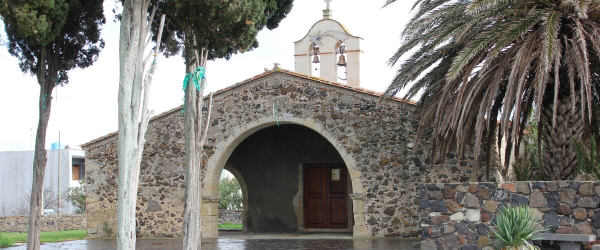 A stone church with a bell tower and an arched entrance.