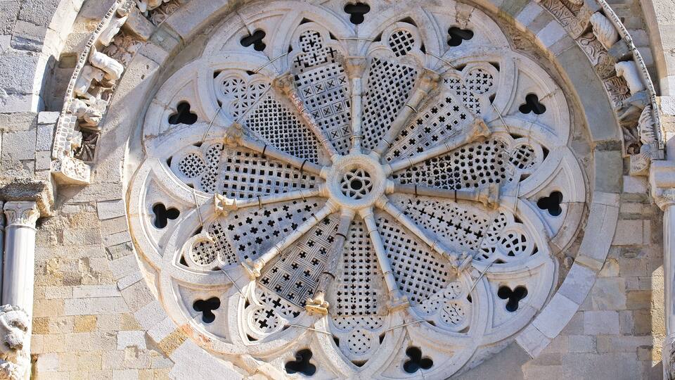 A detailed stone rose window with intricate patterns and a circular design.