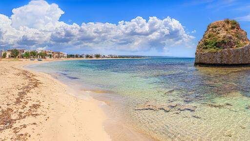 Salento coast: Torre Pali in Apulia, Italia.The ruined sixteenth century watchtower of Torre Pali, surrounded by crystal clear water, appears in the blue water, a few metres away from the coast.