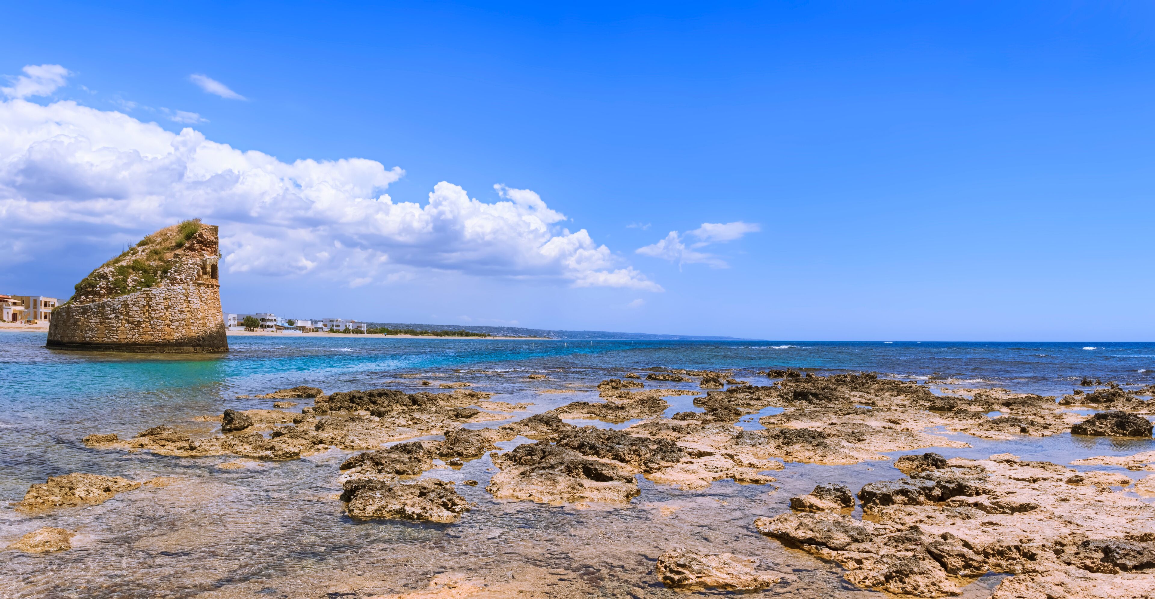 Salento coast: Torre Pali in Apulia, Italia.The ruined sixteenth century watchtower of Torre Pali, surrounded by crystal clear water, appears in the blue water, a few metres away from the coast.