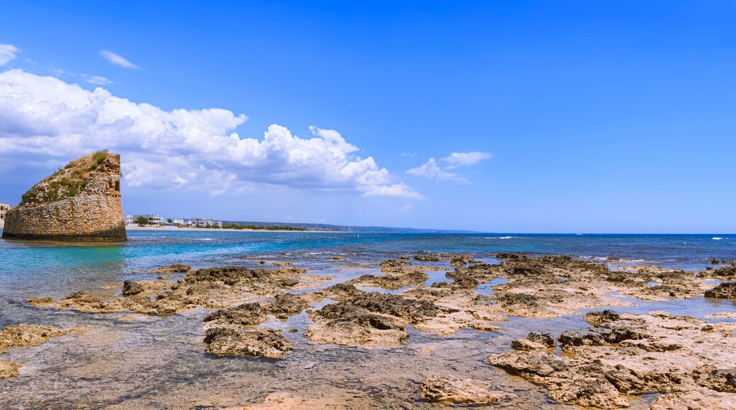Salento coast: Torre Pali in Apulia, Italia.The ruined sixteenth century watchtower of Torre Pali, surrounded by crystal clear water, appears in the blue water, a few metres away from the coast.