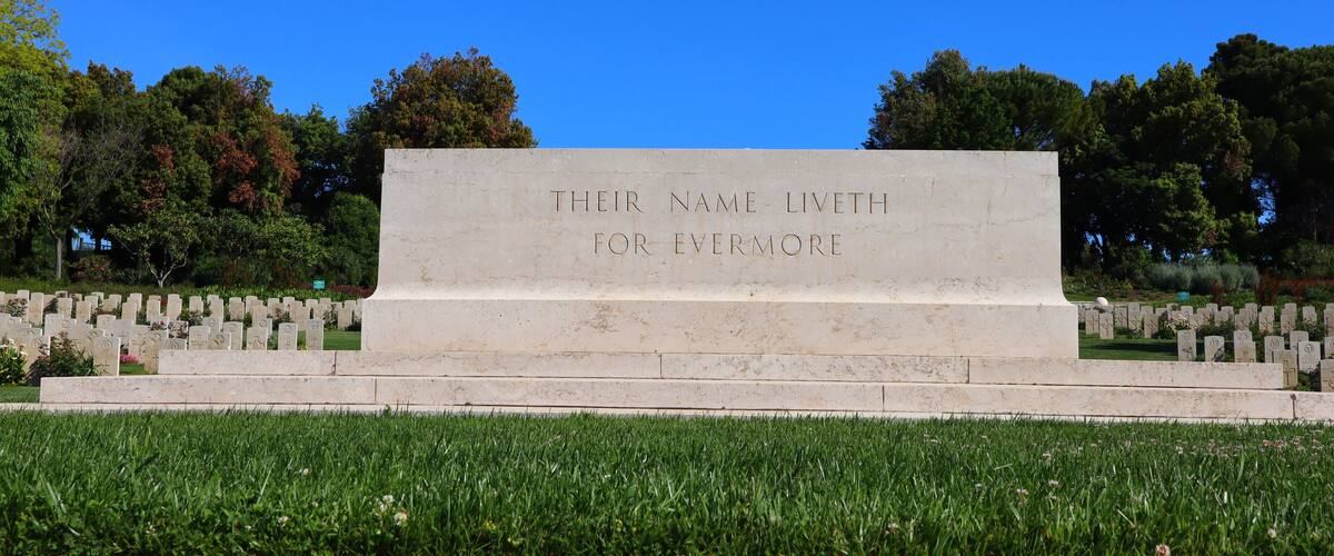 A memorial with a plaque reading "THEIR NAME LIVETH FOR EVERMORE" surrounded by gravestones.