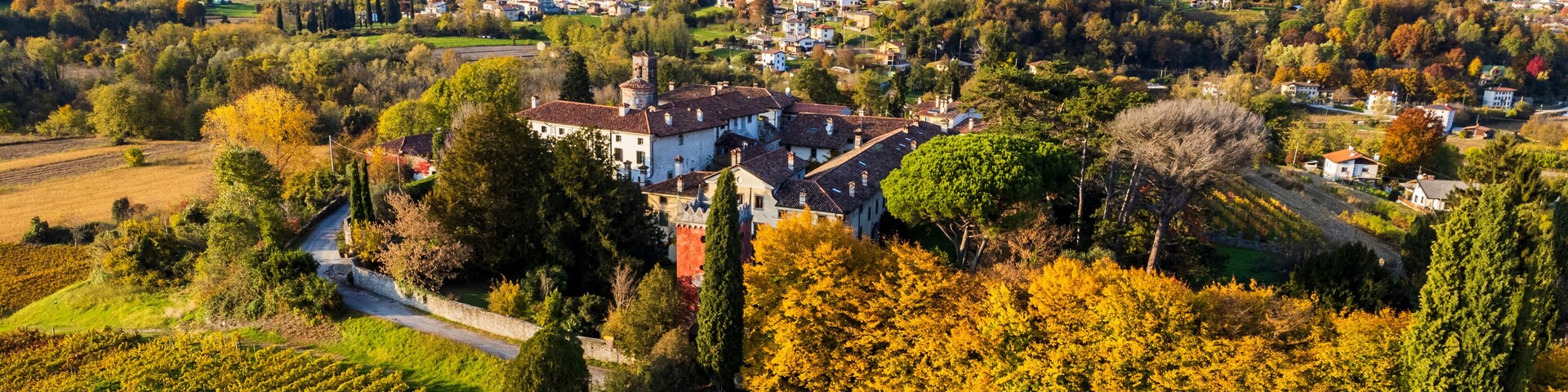 Autumnal magic and emotions on the ancient village. Between vineyards and colorful woods. Friuli. Top view