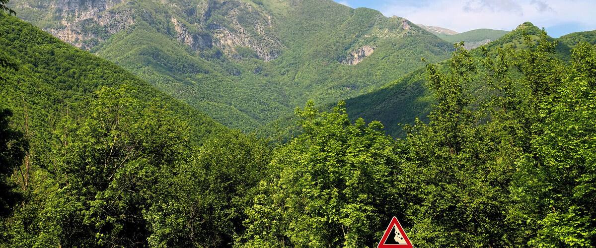 A mountainous landscape with lush green forests and a clear sky.