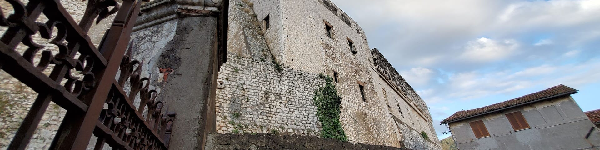 A historic stone building with a weathered facade and a prominent tower.