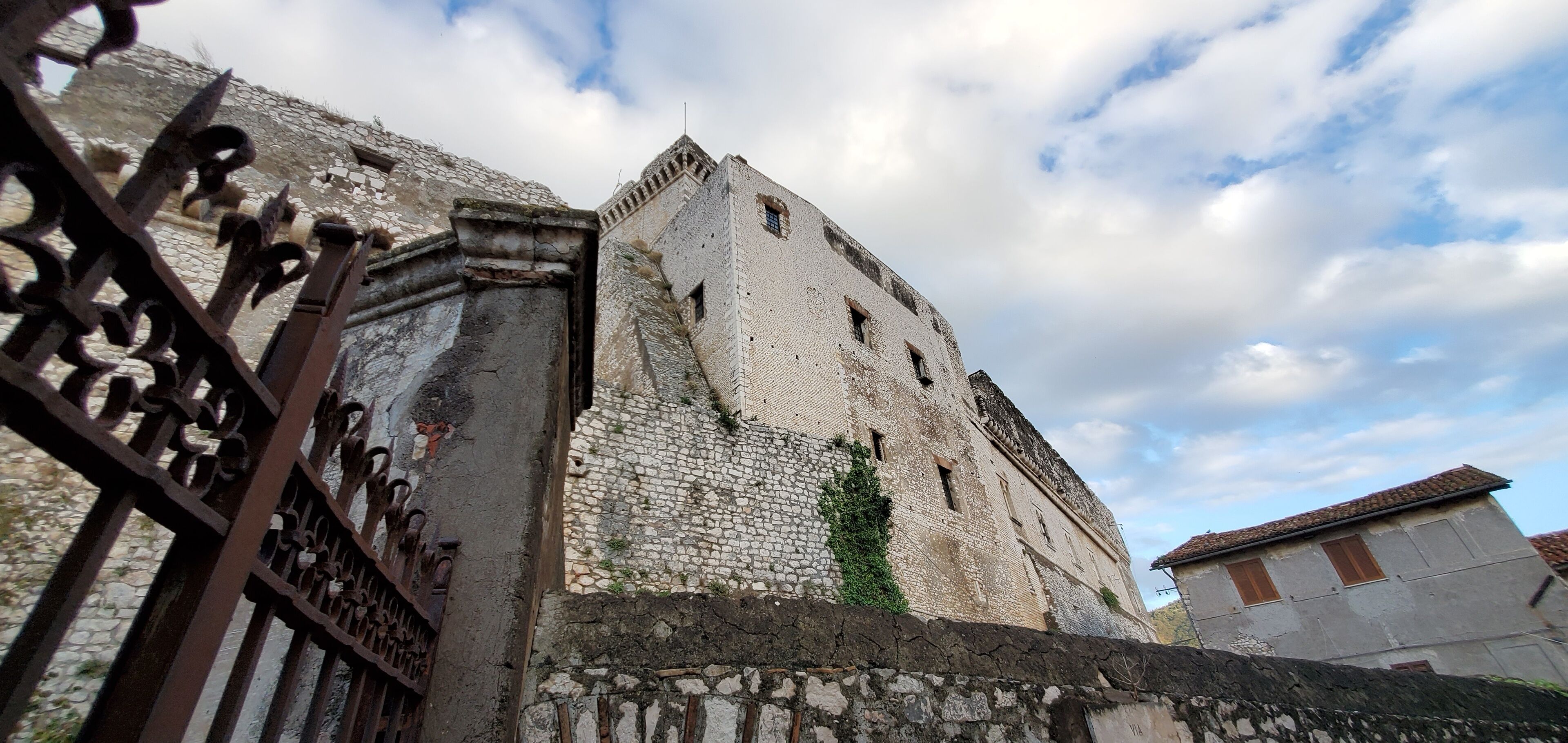 A historic stone building with a weathered facade and a prominent tower.